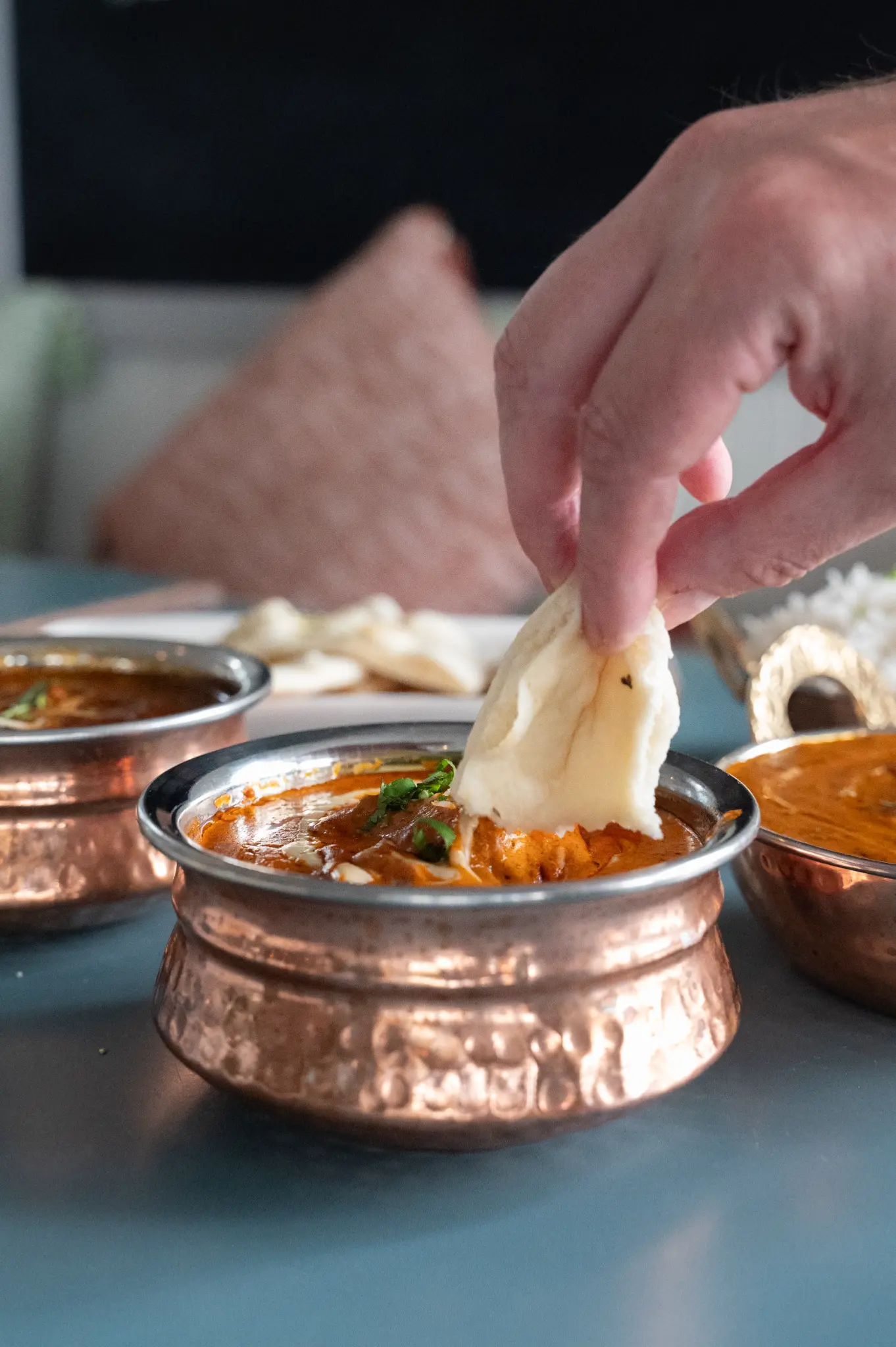 Naan being dipped into curry — Bombay at Bucklands